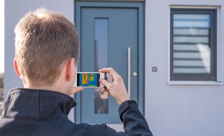 Bild Ein Spezialist prüft die Energieeffizienz der Türen und Fenster aus Kunststoff oder Aluminium