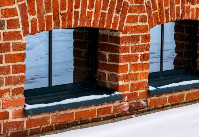 Bild Dunkle, kleine Kellerfenster aus Aluminium in Ziegelmauer