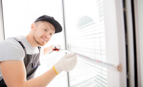 Fenster richtig ausmessen Bild Servicemitarbeiter misst einen Fensterflügel mit dem Maßband aus