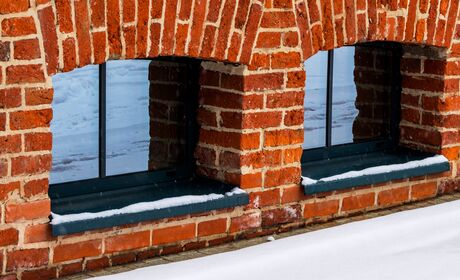 Bild Dunkle, kleine Kellerfenster aus Aluminium in Ziegelmauer