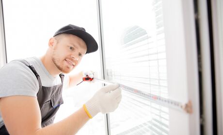 Bild Servicemitarbeiter misst einen Fensterflügel mit dem Maßband aus
