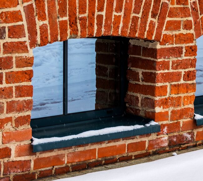 Bild Dunkle, kleine Kellerfenster aus Aluminium in Ziegelmauer