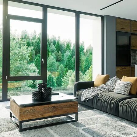 Bild Wohnzimmer mit Aluminium Panoramafenster in dunkler Farbe und Holzzusätze mit moderner Küche hinten und Aussicht auf Wald