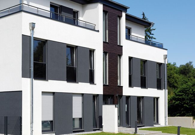 Bild Mehrfamilienhaus mit hellen Rollläden