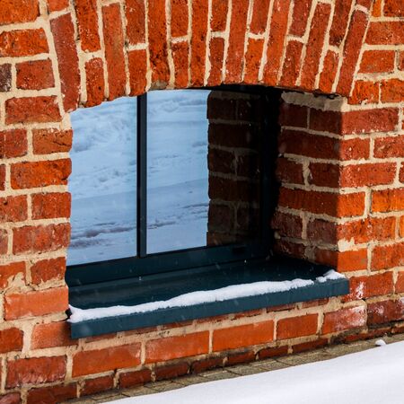 Bild Dunkle, kleine Kellerfenster aus Aluminium in Ziegelmauer