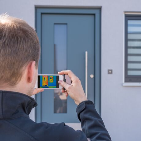 Bild Ein Spezialist prüft die Energieeffizienz der Türen und Fenster aus Kunststoff oder Aluminium